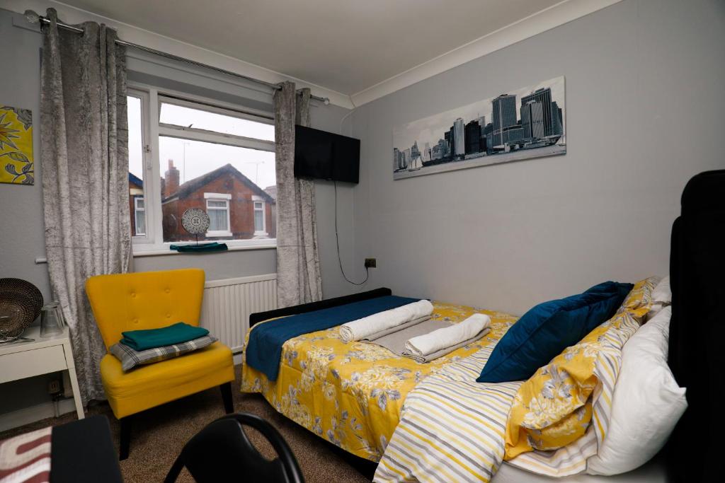a bedroom with a bed and a chair and a window at Harmony Haven - Harmony Suite in Nottingham