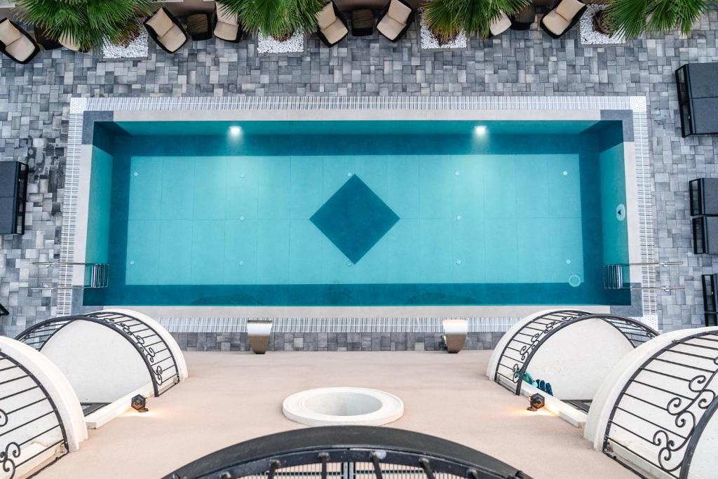 une grande piscine avec trois chaises et une table dans l'établissement Boutique Hotel Bora & Villas Garamm, à Pakoštane