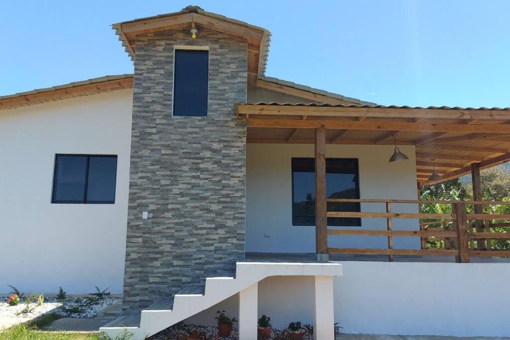 a house with a staircase on the side of it at Cabaña vista a las montañas de manabao in Manabao