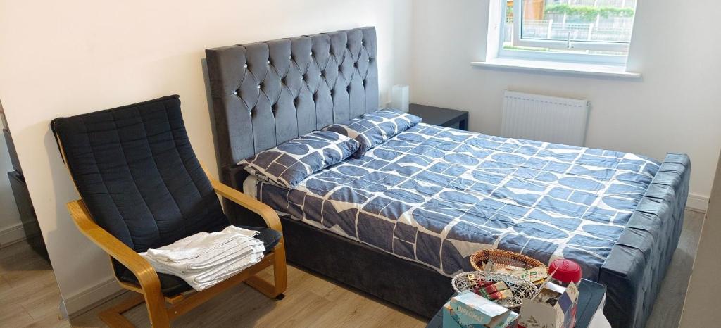 a bedroom with a large bed and a chair at H8 Room 2 Quiet place with 15 min walk to City Centre, Free car parking, Late night Checkin Anytime ,2min walk to bus stop in Manchester