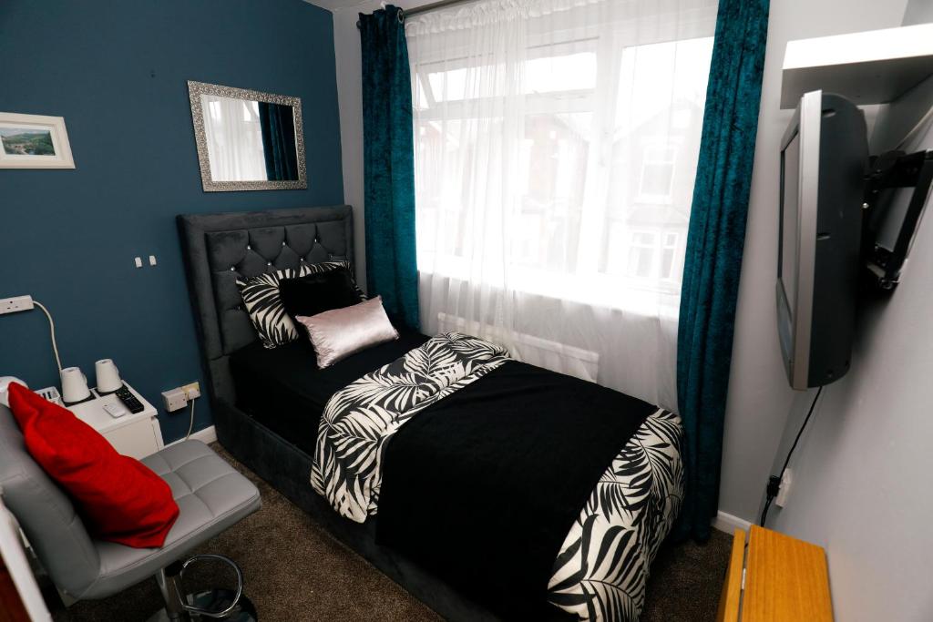 um pequeno quarto com uma cama e uma janela em Harmony Haven - Amity Suite em Nottingham