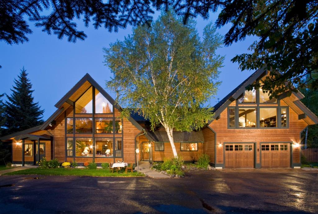 a house with large windows and a tree at Good Medicine Lodge in Whitefish