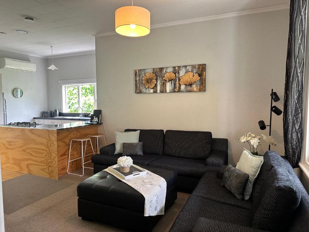 sala de estar con sofá y cocina en SHORT WALK TO NELSON CITY CENTRE - fast ultra-fibre broadband, quiet location, en Nelson