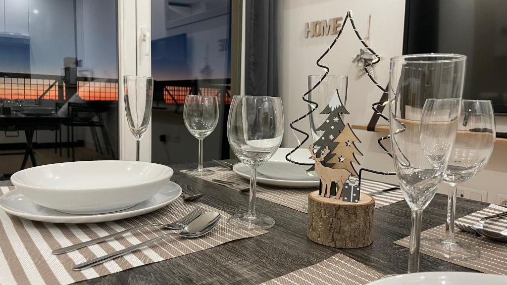 a table with wine glasses and a christmas tree on it at HOUSE TERRAZA PREMiUM 6PAX WIFI in Sierra Nevada
