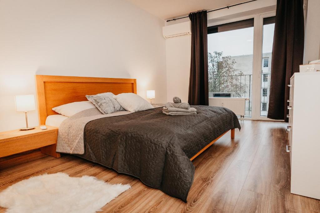 a bedroom with a bed and a large window at Old Town city center apartment 2 - private parking included in Košice