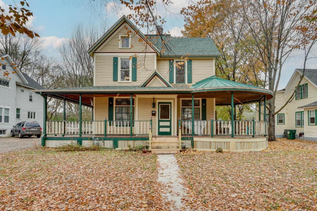 a house with a front porch with leaves on the ground at Eau Claire Retreat Close to Chippewa Riverfront! in Eau Claire