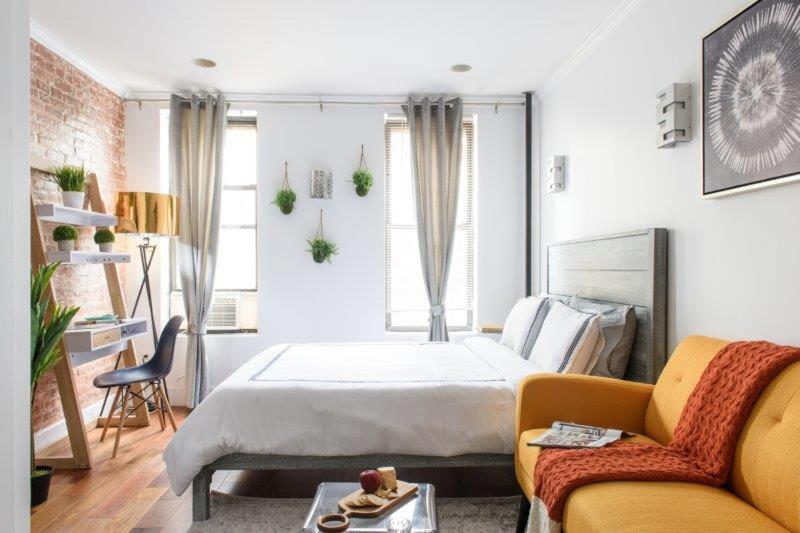 - une chambre avec un grand lit et un canapé dans l'établissement New Prime Gramercy Subway W D in unit, à New York