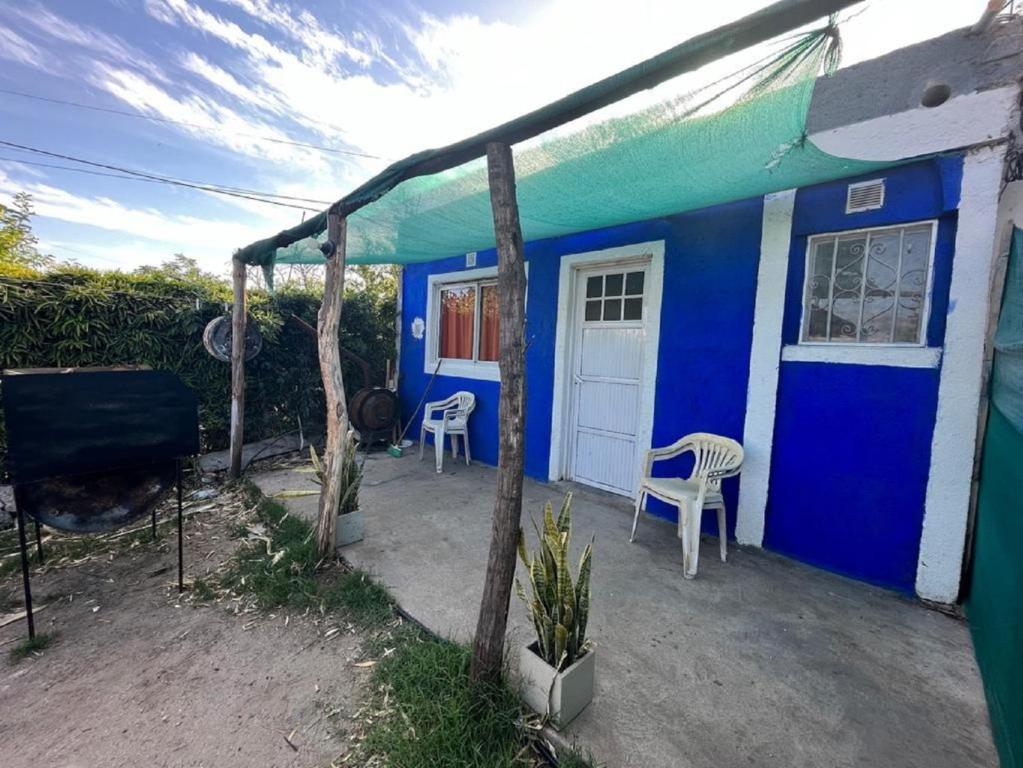 uma casa azul e branca com cadeiras em frente em La Pintada Economy Class em Villa Dolores