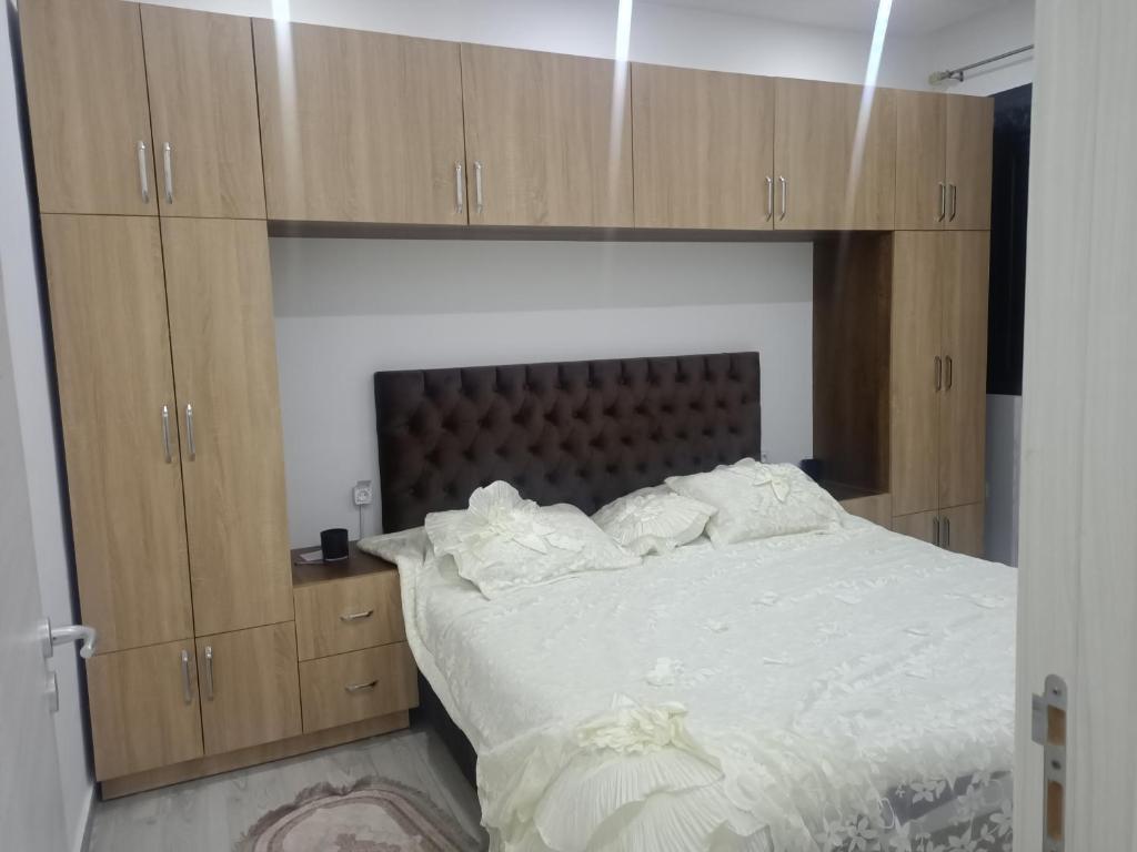 a bedroom with a large bed with wooden cabinets at Résidence kadicia fernuauvil in Oran