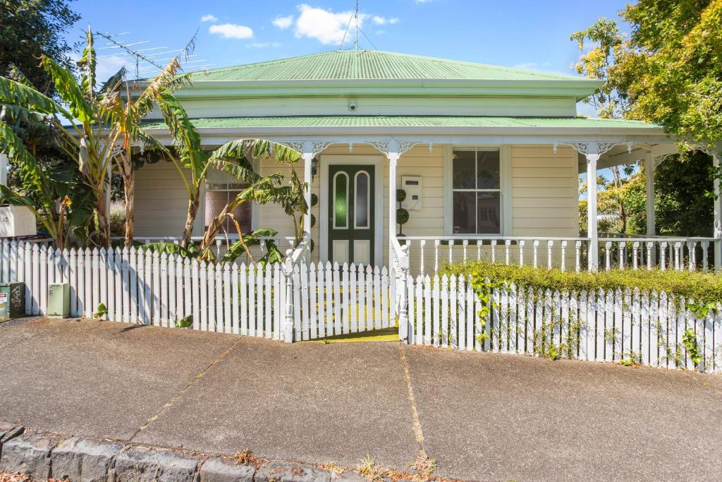 une clôture blanche devant une maison blanche dans l'établissement Quiet secret garden Sun-trap, à Auckland