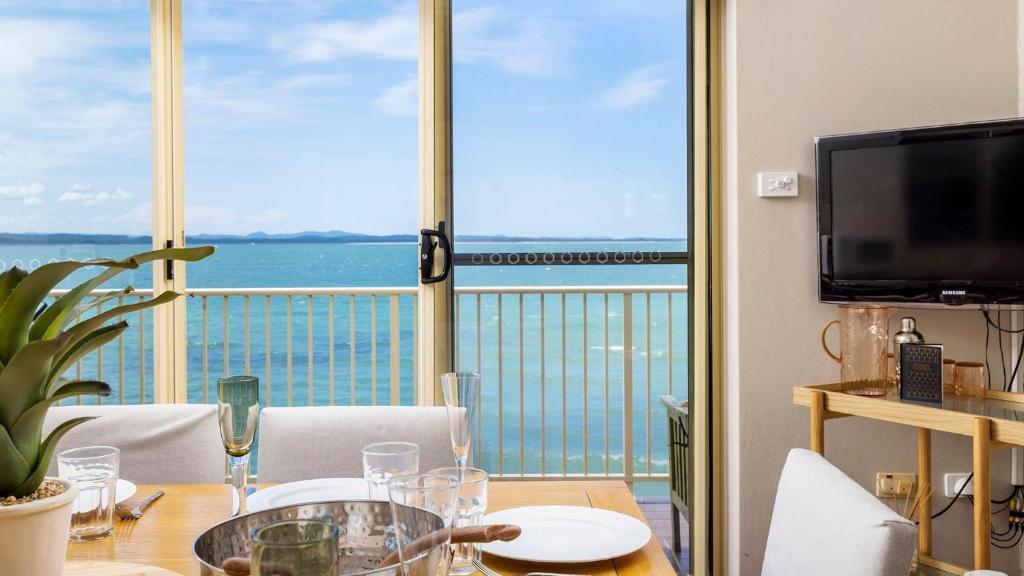 a dining room with a table with a view of the ocean at Alcheringa - Units 3 & 4 32 Sandy Point Rd in Corlette
