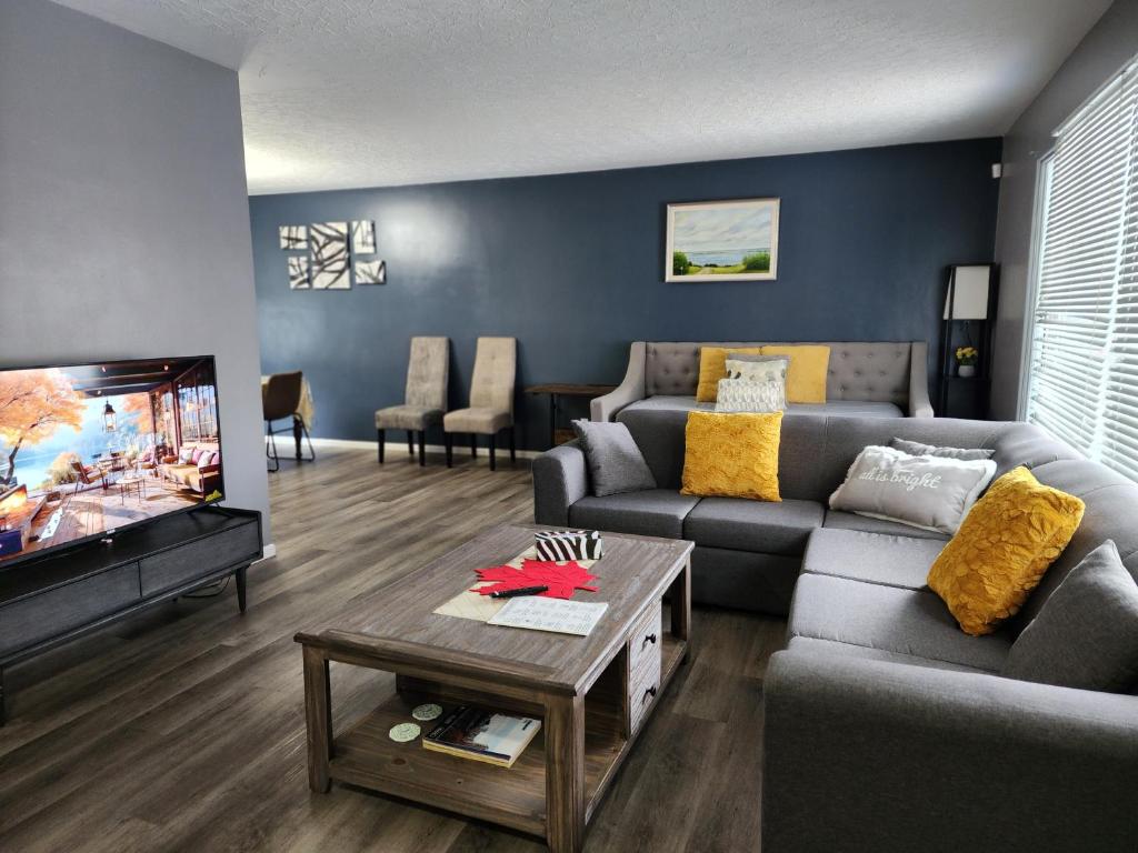 sala de estar con sofá y TV en TheSunshine: Bright&Peaceful 2 Bdrm Character Home en Saskatoon