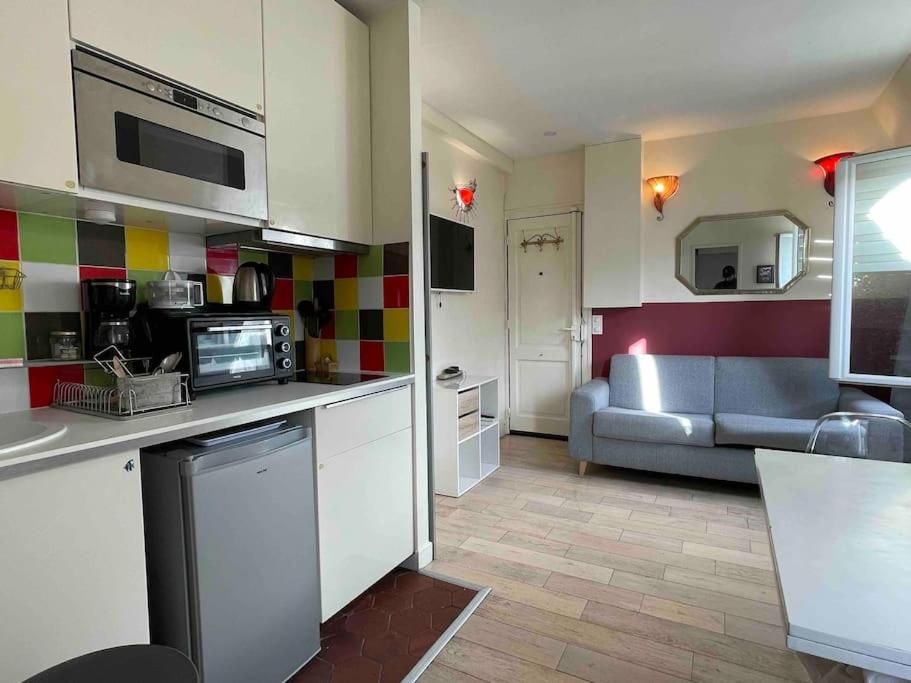 une cuisine et un salon avec un canapé dans l'établissement Wonderful apartment near Arc de Triomphe 2P, à Paris