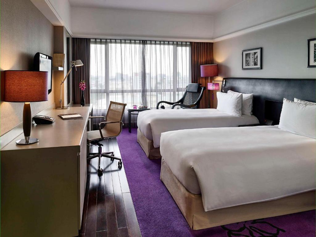 Postel nebo postele na pokoji v ubytování Sofitel Saigon Plaza