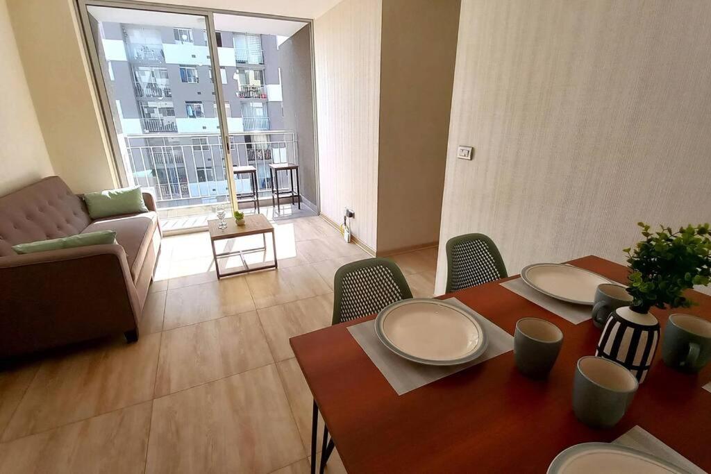 een woonkamer met een tafel en stoelen en een bank bij Depa moderno y tranquilo a 15 min del Aeropuerto in Lima