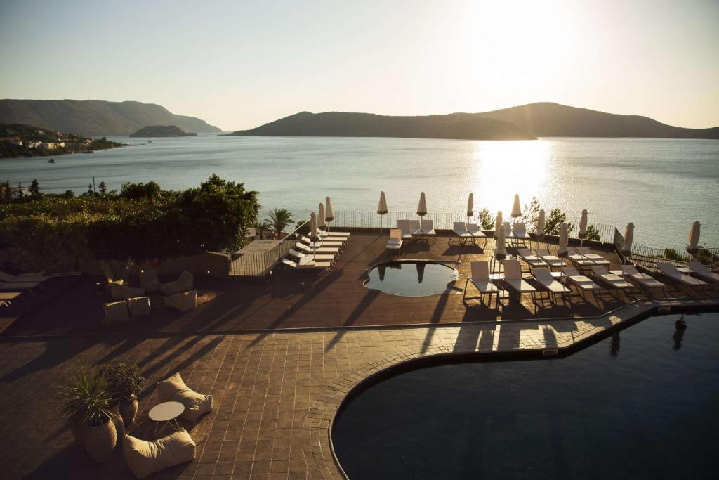 un complejo con piscina y vistas al agua en Domes Aulus Elounda All-Inclusive Resort, Curio by Hilton en Elounda