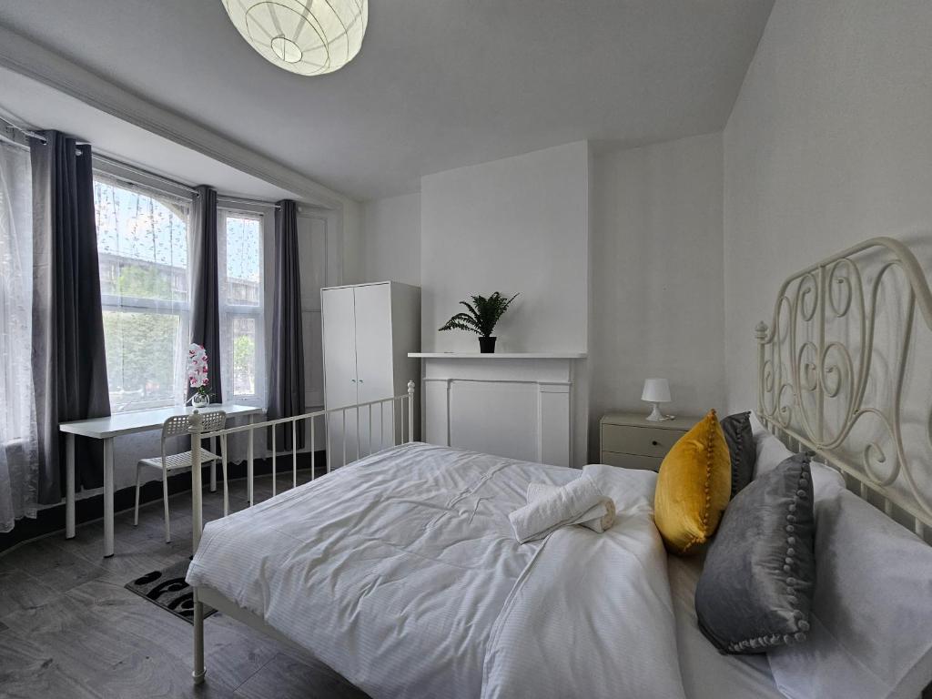 um quarto com uma cama, uma secretária e uma janela em Family room near Queen Mary College em Londres