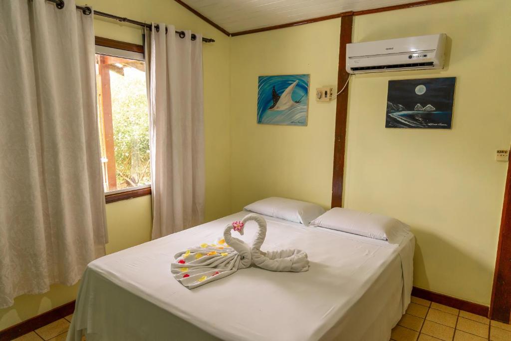 um quarto com uma cama com uma decoração de cisne em Pousada do Romildo em Fernando de Noronha