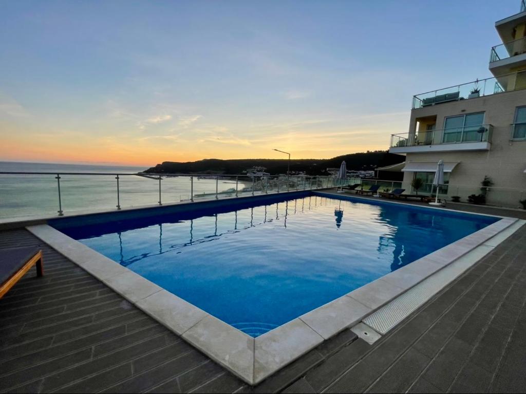 een groot zwembad naast een gebouw en de oceaan bij Sesimbra Mar e Sol in Sesimbra