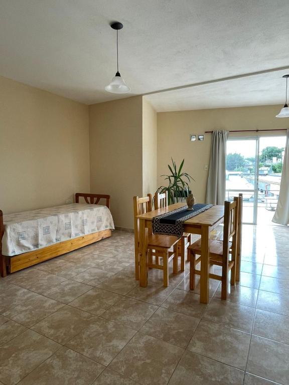 een slaapkamer met een bed en een tafel en stoelen bij Departamento Alta Gracia in Alta Gracia