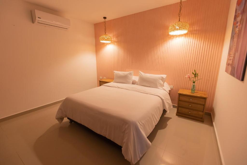 1 dormitorio con cama blanca y mesita de noche en Rocco Hotel Bed & Breakfast, en Cartagena de Indias