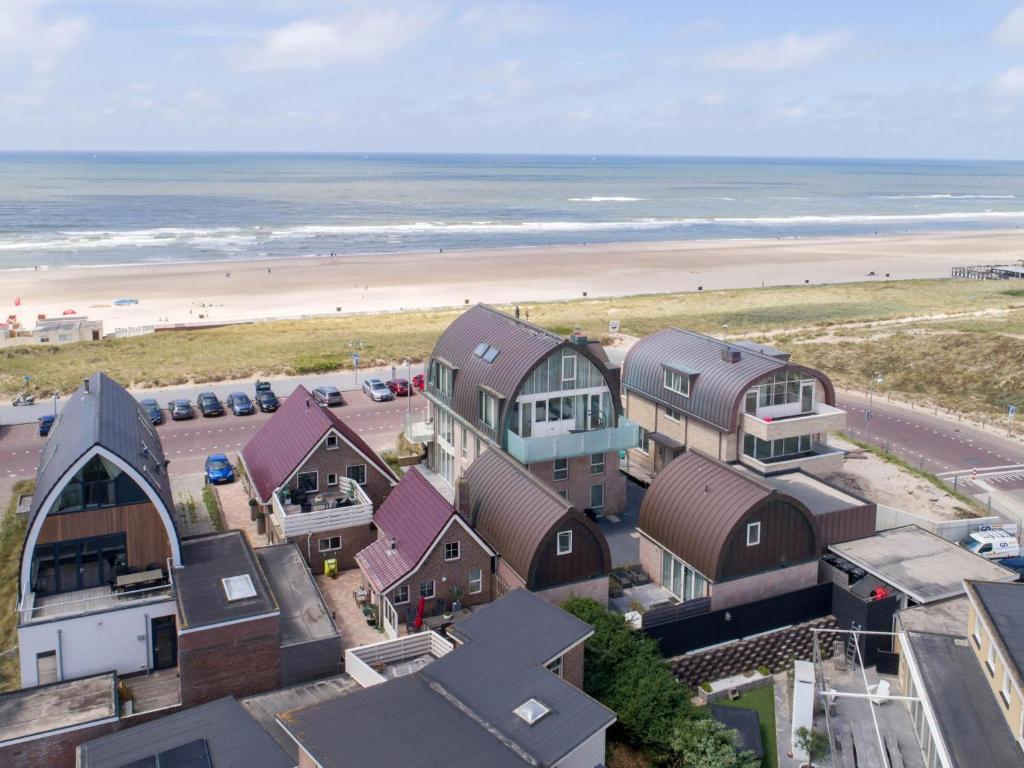 eine Luftblick auf einen Strand mit Häusern und das Meer in der Unterkunft Zeebaars in Egmond aan Zee