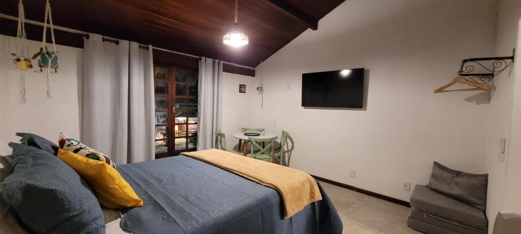 a bedroom with a bed and a tv on the wall at Studio 6 in Búzios