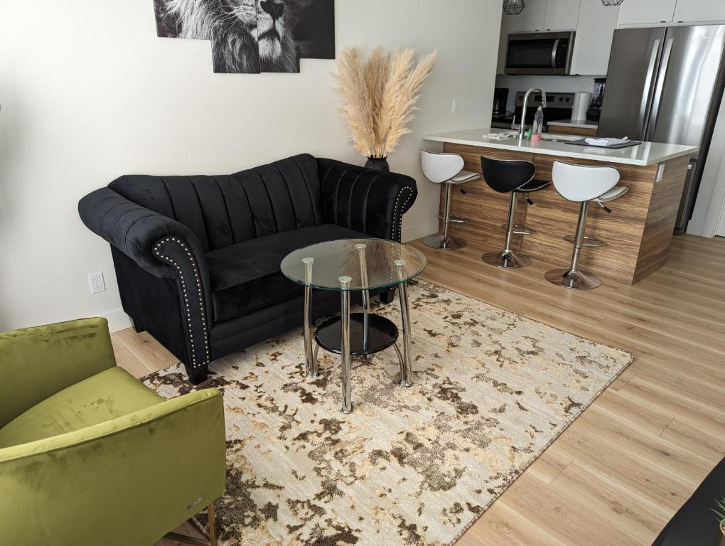 a living room with a black couch and a table at Comfy 2BR condo in Seton, Southeast Calgary in Calgary