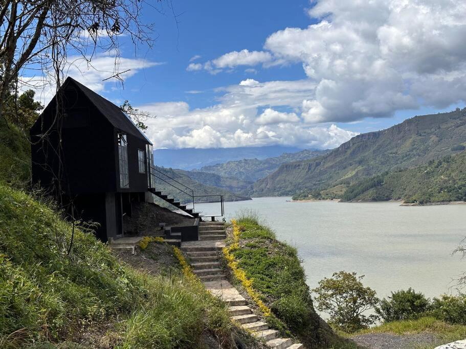 una casa su una collina vicino a un corpo d'acqua di Casa Lanzo, montañas y lago a Macanal