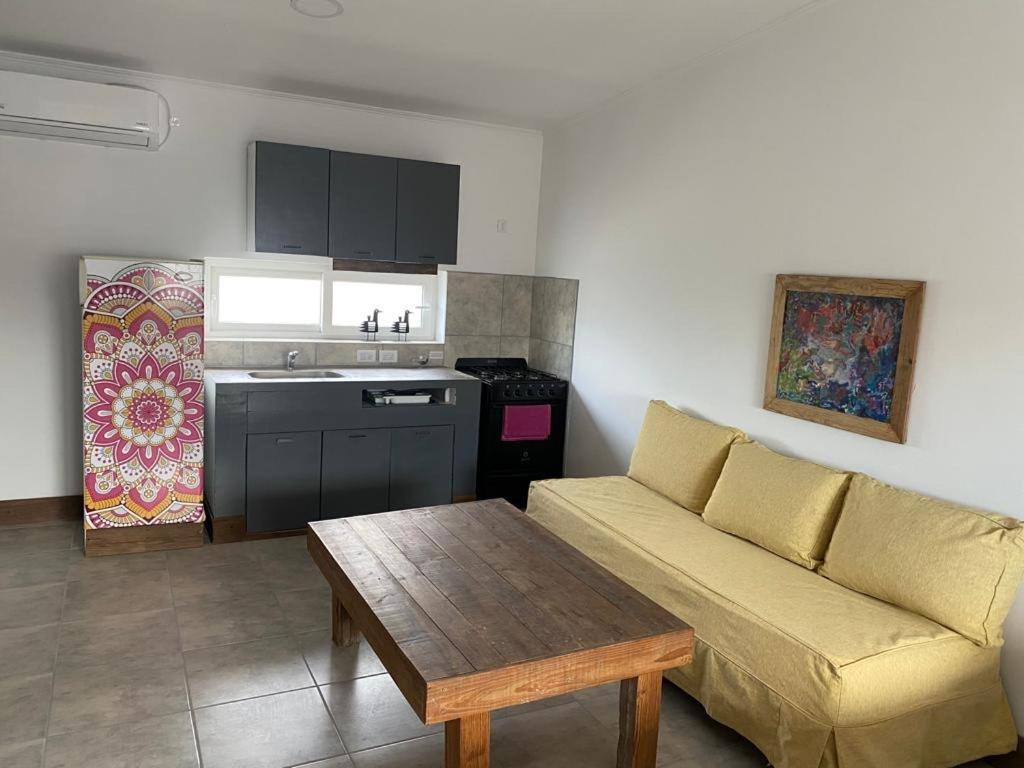 uma sala de estar com um sofá, uma mesa e uma cozinha em La Higuera con Parking B em Azul
