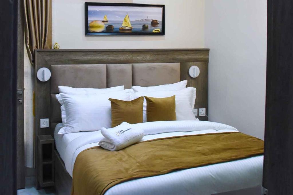 1 dormitorio con 1 cama grande con almohadas blancas en Castle Estate Apartments, en Abuja