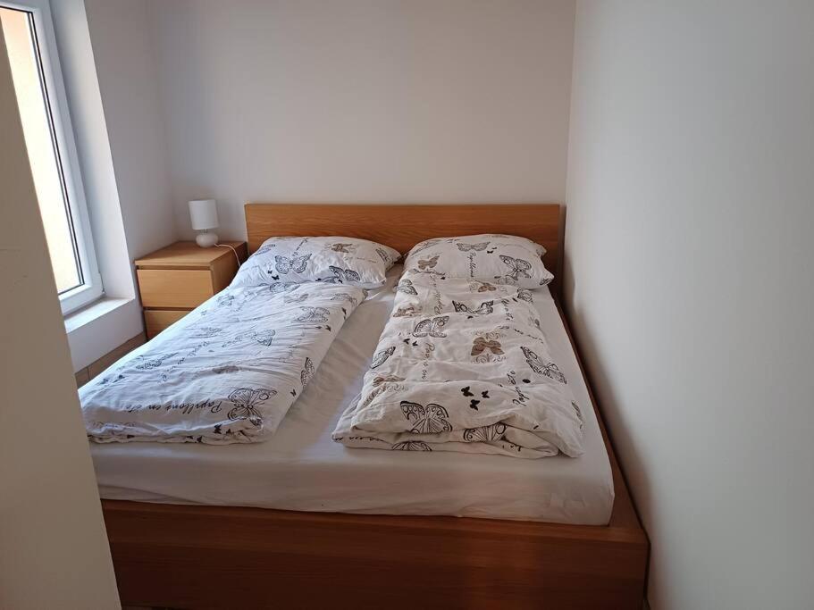 łóżko z dwoma poduszkami obok okna w obiekcie Apartmán Knín w mieście Nový Knín