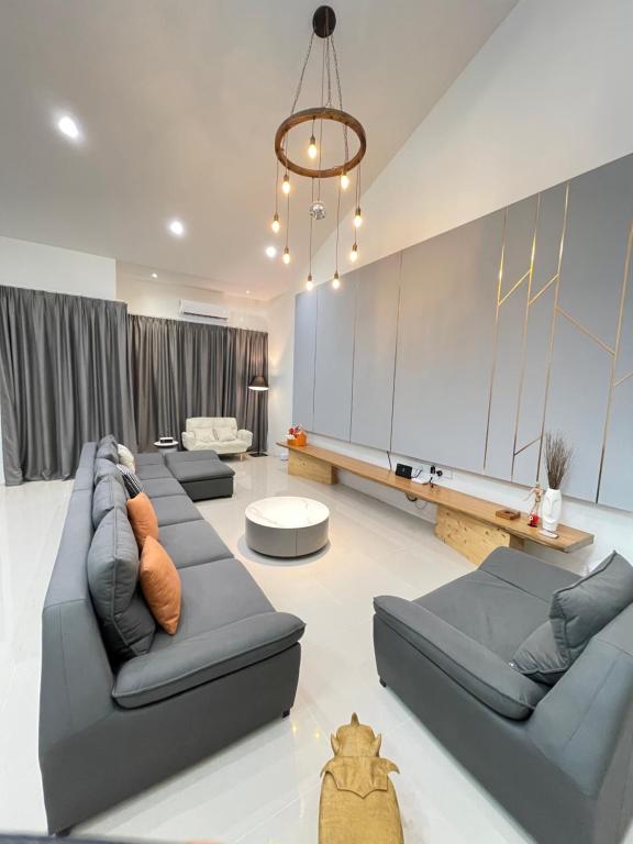 uma ampla sala de estar com sofás e um lustre em Anna 温馨住家住宅 em Sibu