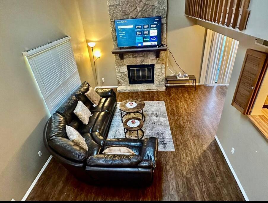 a living room with a leather couch and a television at The Cozy Townhouse WPAFB & WSU in Fairborn