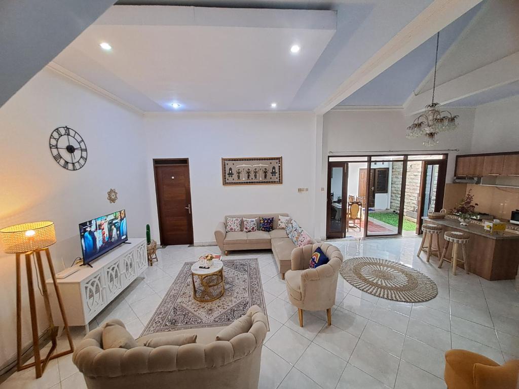 uma grande sala de estar com sofás e uma televisão em Villa Wangko em Tanjungkarang