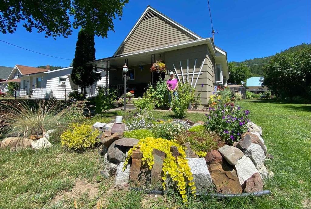 a garden in front of a house with flowers at Silver Valley Getaway in Kellogg