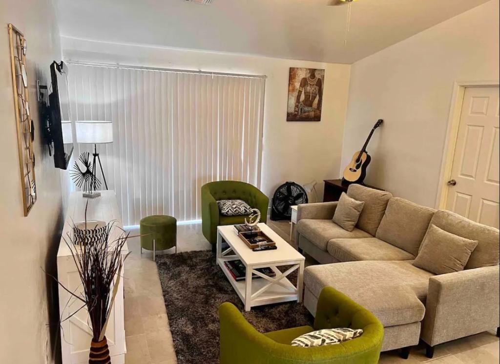a living room with a couch and chairs and a guitar at Vernon House - Stunning Cozy Vacation Home Near State Farm Stadium with Gym-Kitchen-Free Parking in Phoenix