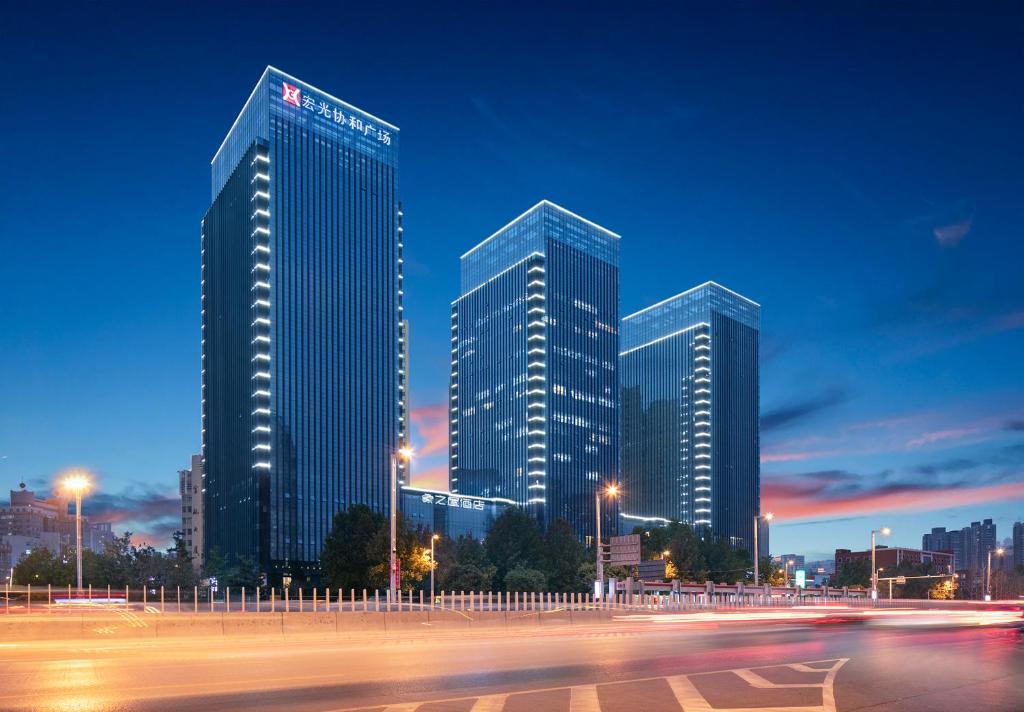 a group of tall buildings in a city at night at Zhengzhou The Grand House in Zhengzhou