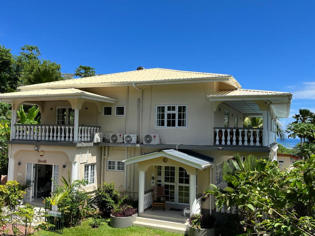 a large white house with a balcony at Royal Bay Villa in Anse Royale