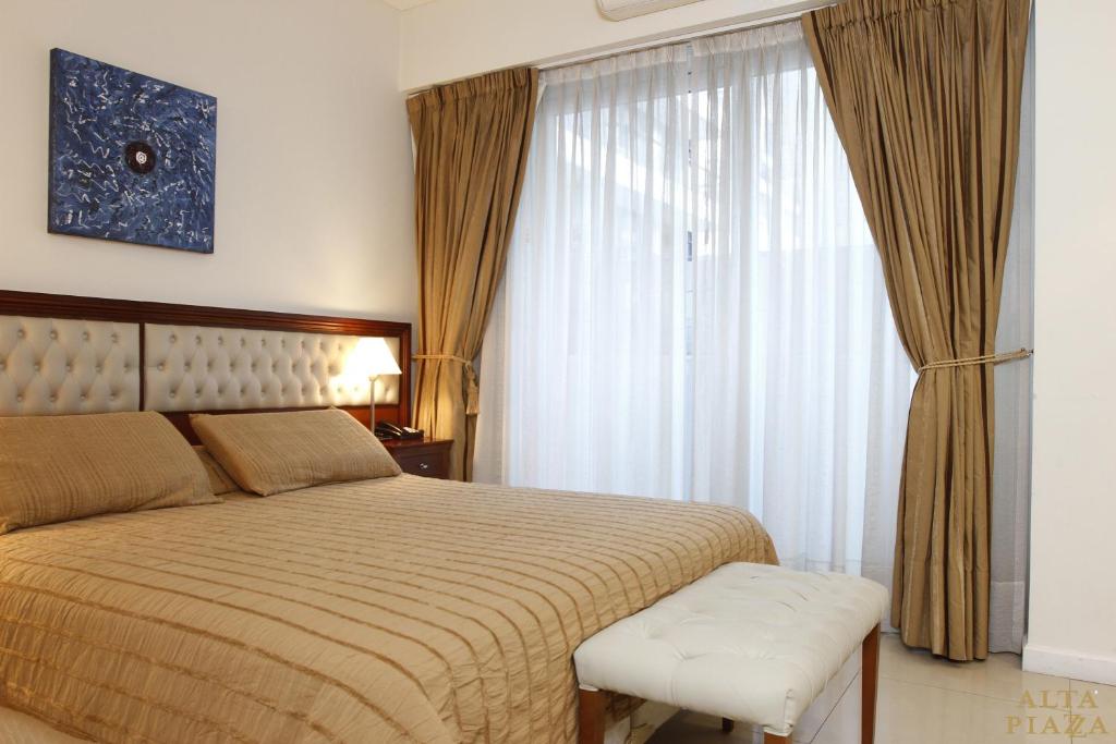 a bedroom with a large bed and a window at Alta Piazza –Casa di Appartamenti– in Buenos Aires