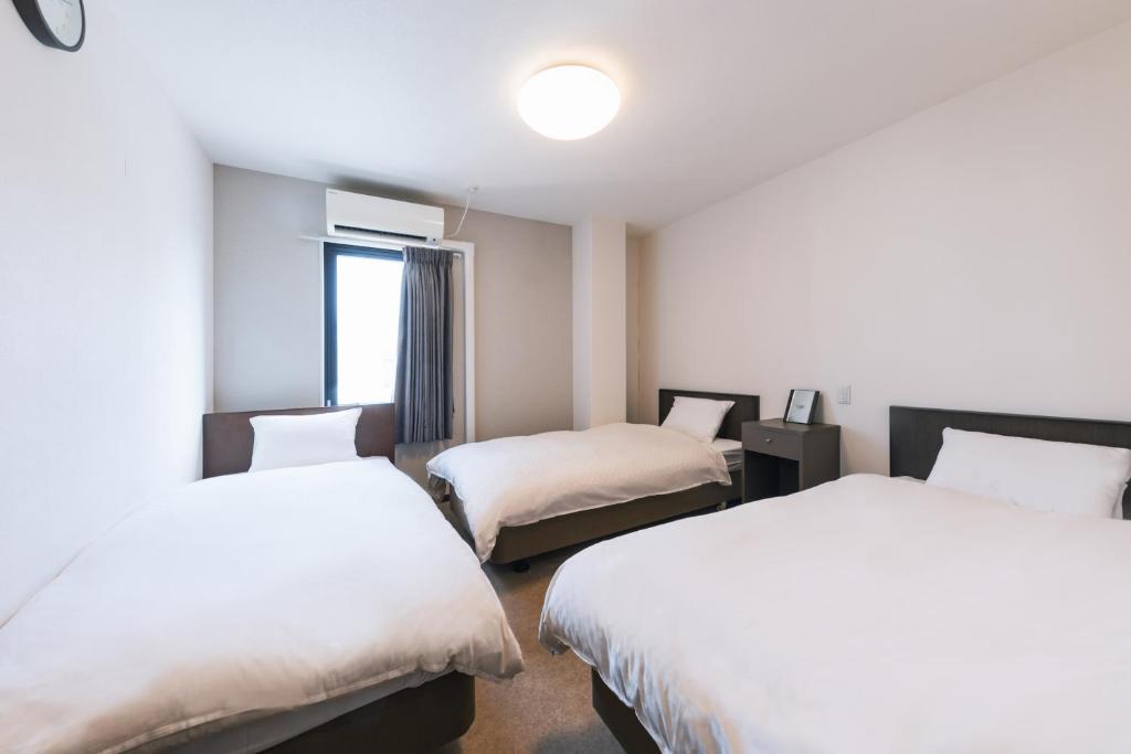 Postel nebo postele na pokoji v ubytování OKINI HOTEL namba