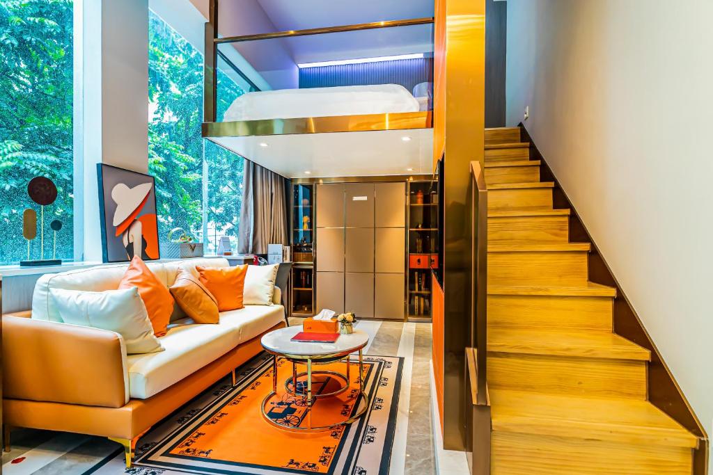 sala de estar con sofá y escalera en Yunga Yee Tsui Apartments云嘉倚翠公寓, en Guangzhou