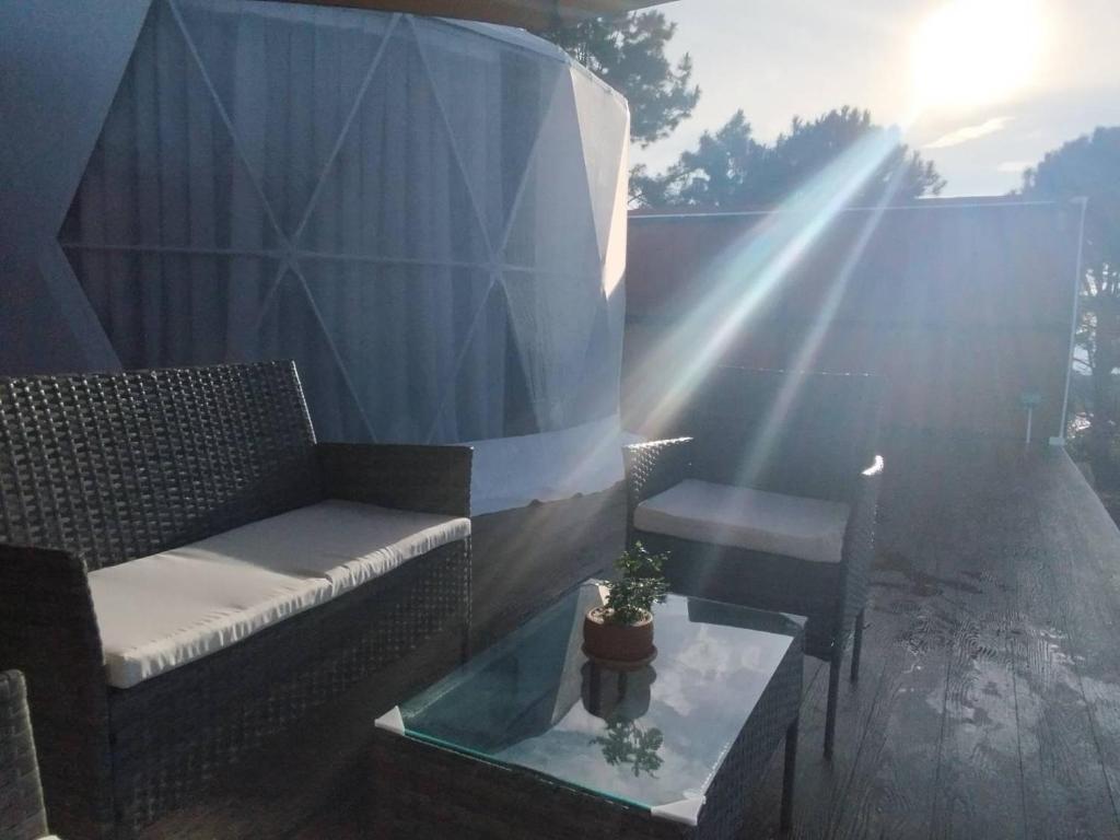 a patio with a couch and a table with a plant at Green bus view inside hills khaokho in Khao Kho