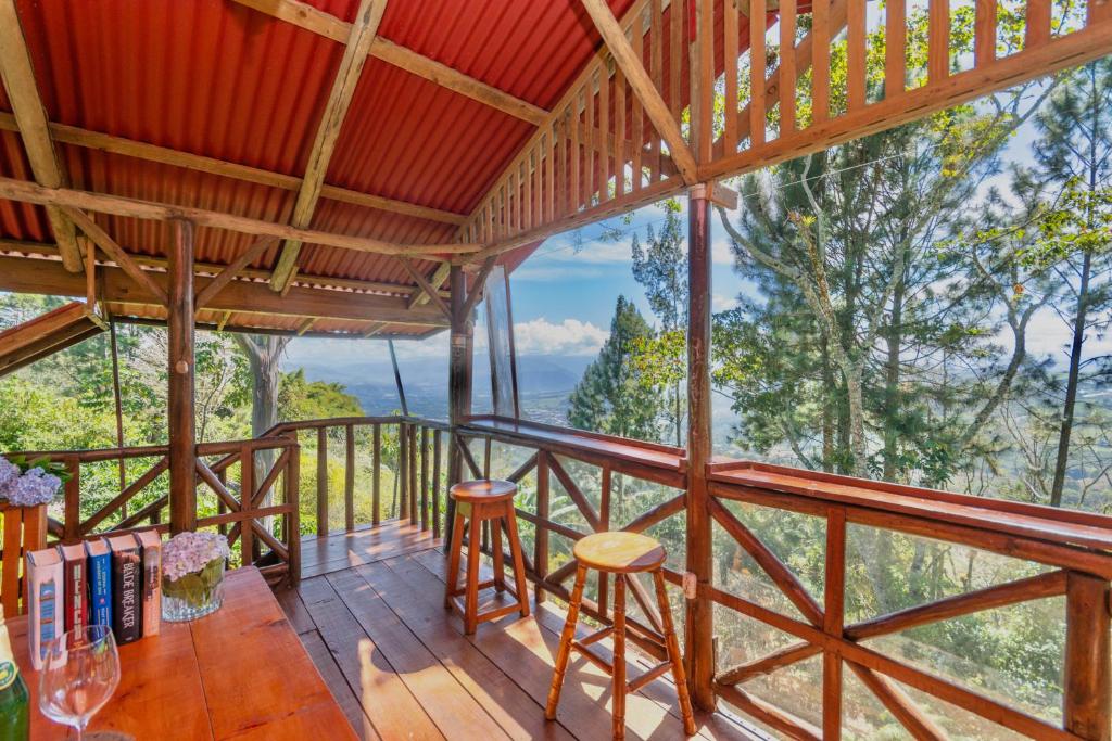 a room with a balcony with a table and chairs at Vista Turrialba Lodge in Turrialba