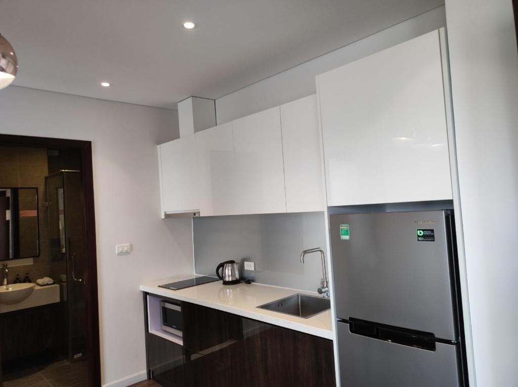 a kitchen with white cabinets and a stainless steel refrigerator at Homestay Bắc Ninh in Bắc Ninh