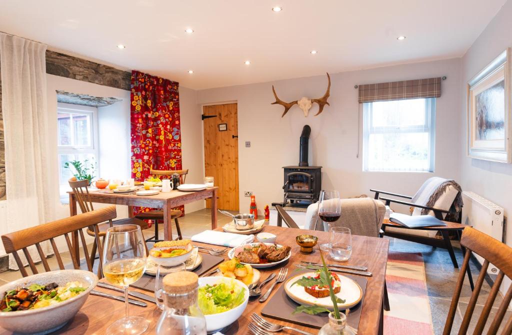 een eetkamer en een woonkamer met een tafel met eten bij Stone Barn in Skibbereen