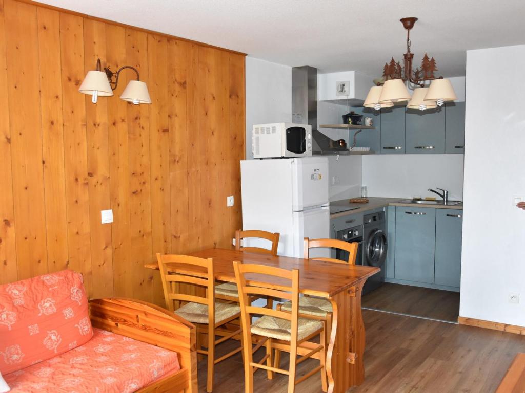 une cuisine et une salle à manger avec une table et des chaises dans l'établissement Appartement cosy avec balcon, parking et piscine à 300m du centre et 500m des pistes - FR-1-464-223, à Pralognan-la-Vanoise