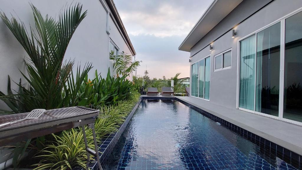 a house with a swimming pool next to a building at Green Lung Pool Villas Bangkok in Bang Krasop