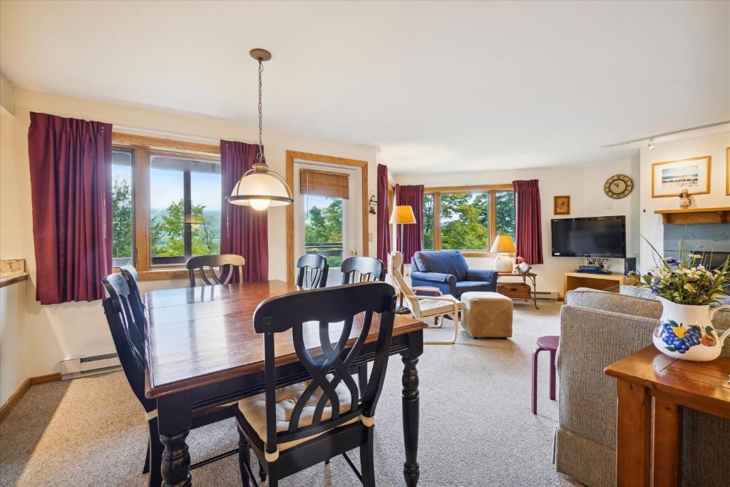 a dining room and living room with a table and chairs at Incredible Highridge 2 bedroom 2 bathroom with Indoor Pool A14 in Killington
