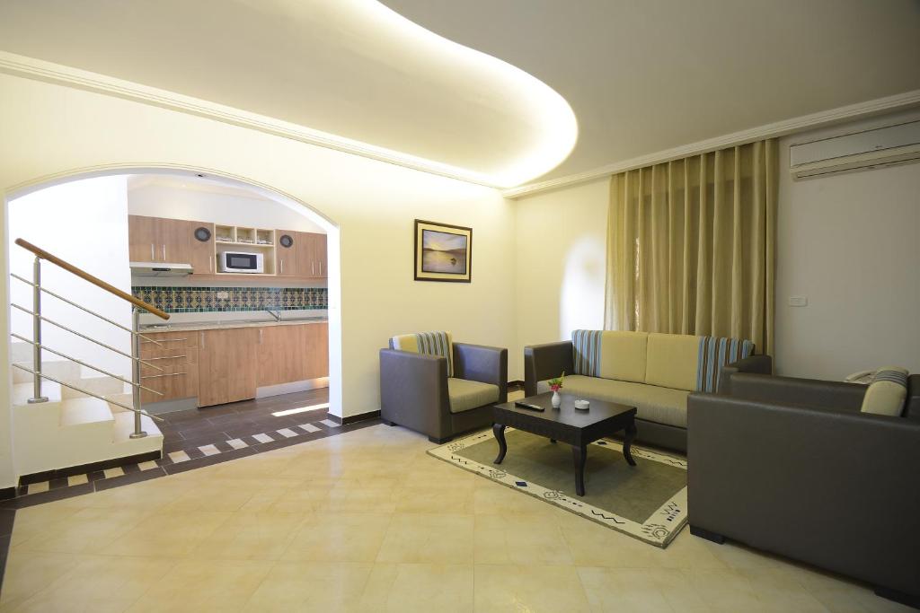 a living room with two couches and a table at Palm Djerba Suites in Mezraya